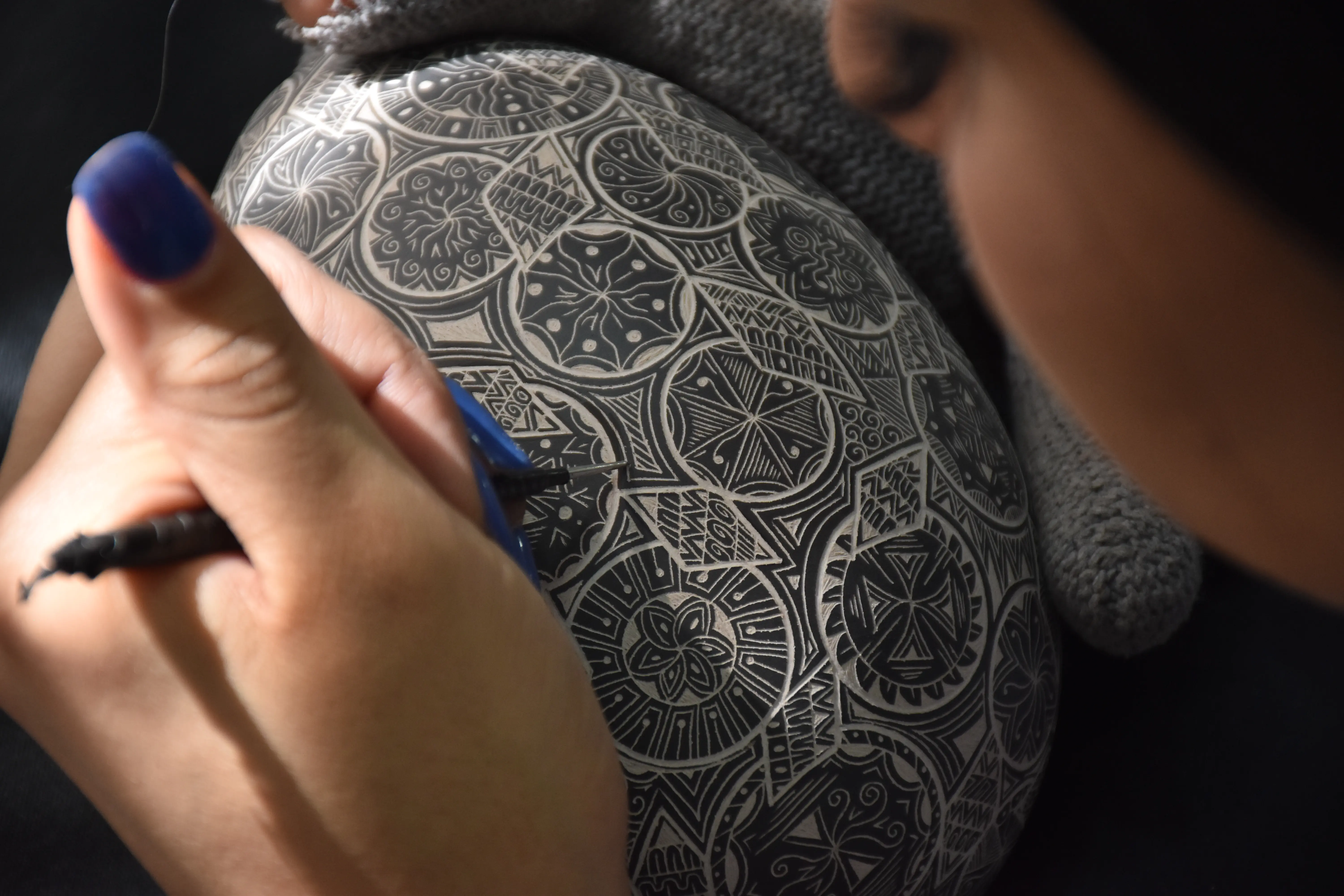 Detalle de grabado artesanal sobre barro negro realizado por artesana en Chihuahua.
